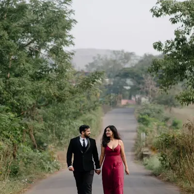 A walk down a quiet country road, surrounded by lush greenery. This wide shot establishes a sense of journey and togetherness, perfect for a destination pre-wedding story.
