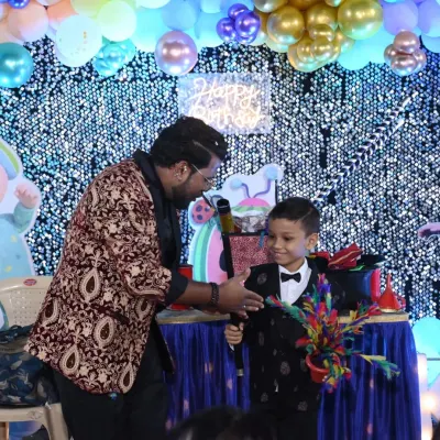 Making the birthday boy the star of the show. Here, he's helping me with a colorful flower wand trick, creating a magical moment just for him.