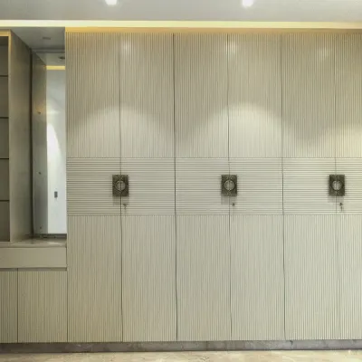 A full-wall wardrobe solution featuring fluted paneling and integrated dressing unit. The off-white PU finish creates a bright, sophisticated look while offering immense storage.