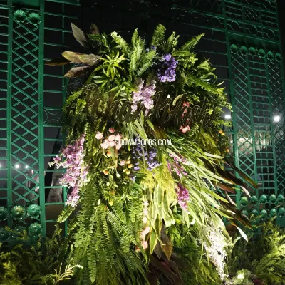 A personalized floral installation for Rohan and Ashima's wedding, with their names crafted in gold and set amidst a lush arrangement of ferns and flowers.