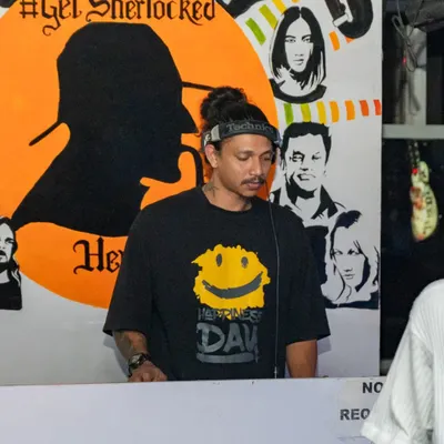 Here's DJ Kevin in his element, spinning tracks in front of our custom "Get Sherlocked" mural. He's a master at creating an unforgettable party atmosphere.