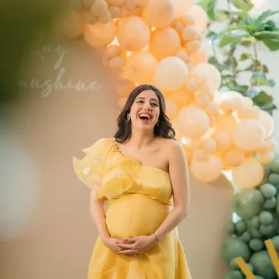 The pure joy and laughter of a mom-to-be at her baby shower. This candid shot captures her radiant happiness, surrounded by cheerful yellow and green decor.