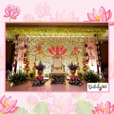 The main stage for a traditional Uttadatti ceremony, designed to feel majestic. A central throne is framed by a stunning wall of white and gold flowers, a large pink lotus motif, and elegant chandeliers overhead.