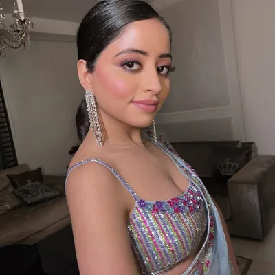 A close-up of a client with a pop of pink on the eyes and a sleek ponytail. This look is crafted with intention to highlight natural beauty.