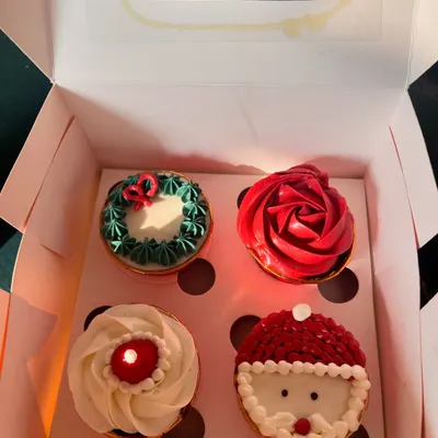 My assorted Christmas cupcakes are so fun to make. This box of four includes a Santa Claus design, a red rose, a wreath, and a simple swirl, all decorated with buttercream.