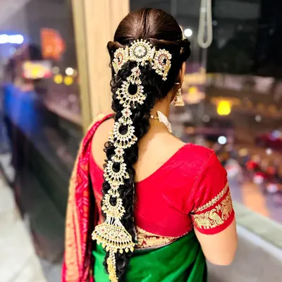 This is a traditional South Indian bridal braid, also known as a 'Jada'. I've decorated it with heavy, intricate gold-plated hair jewelry for a truly royal look.