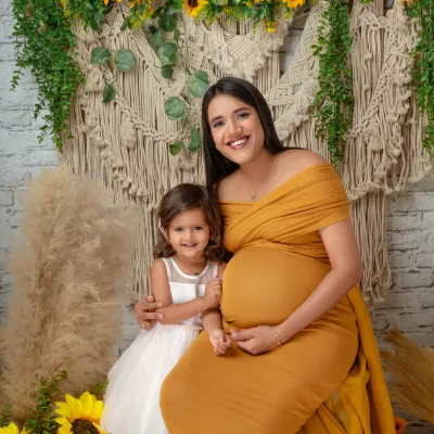 Welcoming a new baby is a family affair. This beautiful maternity portrait includes the older sibling, capturing her excitement about becoming a big sister.