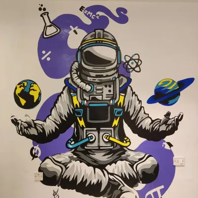 The completed astronaut mural, designed to make learning fun at a Mumbai teaching institute. This graphic wall art features a meditating astronaut surrounded by symbols of science and space, creating a cool and engaging environment.
