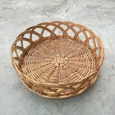This is a shallow, round cane tray with a decorative open-weave rim. It works well as a base for a centerpiece, a fruit platter, or for serving dry foods.