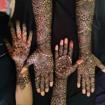 A fun shot of a group of friends showing off their matching and complementary henna designs. It's always more fun to get mehndi done together.