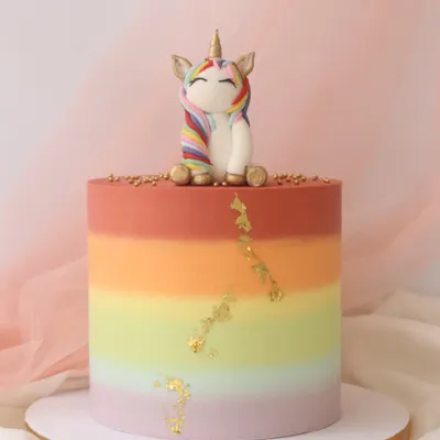A vibrant rainbow gradient cake topped with a cute, sleepy unicorn. I added a touch of edible gold leaf for a little bit of magic.