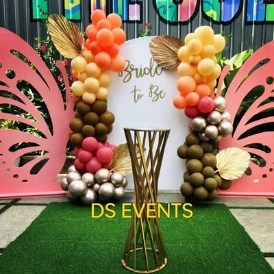 A whimsical 'Bride to Be' backdrop for a bridal shower. This design features large pink butterfly wings, a custom sign, and an organic balloon garland in a trendy color palette of orange, brown, and blush.