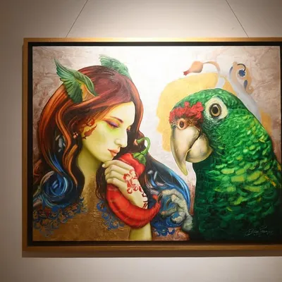 This painting explores the gentle and intimate connection between humans and nature, represented by the woman and the large green parrot. It is a surrealist piece meant to evoke a sense of quiet communication.