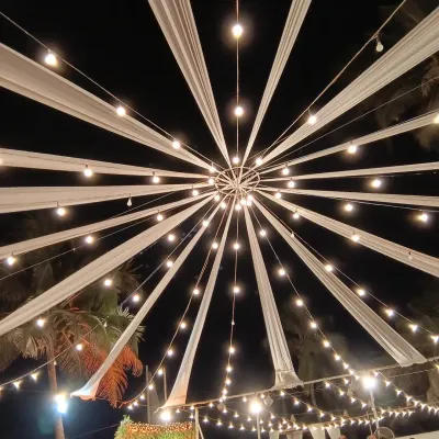 This overhead view showcases a custom lighting installation for a large evening event. The starburst pattern of fabric and lights creates a spectacular focal point, demonstrating my expertise in large-scale, creative lighting solutions.