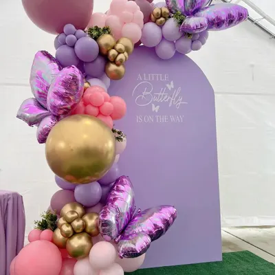 Our butterfly theme is perfect for a modern and graceful baby shower. The custom-arched lavender backdrop provides a beautiful canvas for the elaborate balloon garland and large foil butterflies, creating a truly enchanting scene.
