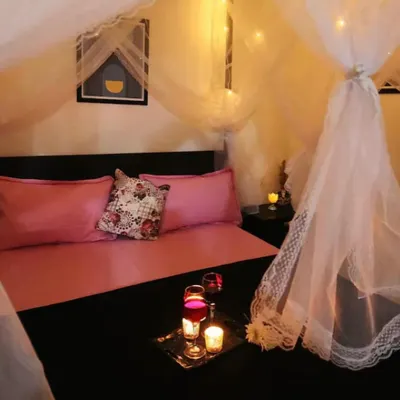 My signature ferry bed setup, complete with a sheer canopy and fairy lights. I'll add a tray with wine and candles for the perfect romantic night.