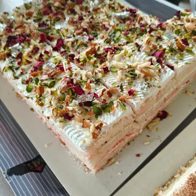 Our Rasmalai sheet cake is a delightful fusion of traditional Indian dessert and classic cake. It's topped with pistachios, almonds, and rose petals.