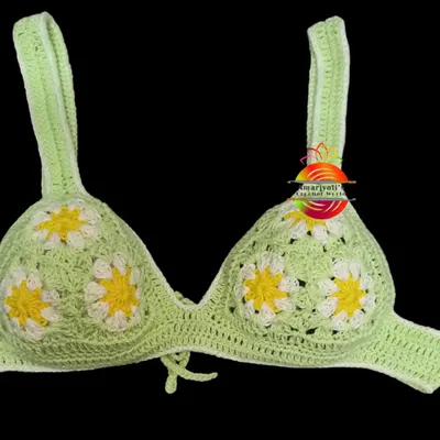 This is the top part of a custom bikini set I made. It features a cheerful daisy granny square pattern on a light green base, perfect for a sunny day at the beach.