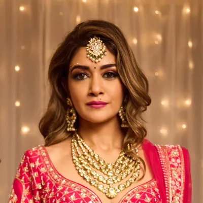 A close-up of a full glam bridal look. This style features a dramatic smokey eye, a bold magenta lip, and perfectly contoured features, paired with voluminous waves for a show-stopping Sangeet or Reception entrance.