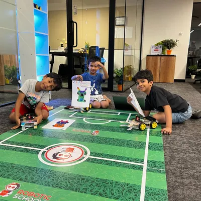 Here are three of my students proudly displaying their custom-designed soccer robots. They are all set for the competition, ready to put their building and programming skills to the test on the field.