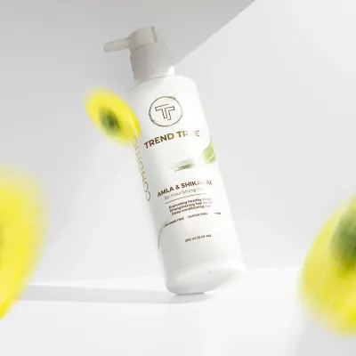 A creative shot of a Trend Tree conditioner bottle, seemingly floating with blurred elements suggesting motion and natural ingredients. This dynamic style is great for capturing attention on social media.