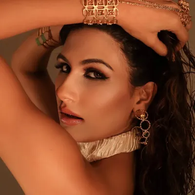 A fierce, golden glam look on Nidhi Tapadia. I created a sharp, graphic winged eye and paired it with a wet-look hairstyle and glossy skin for a high-fashion, almost liquid-gold effect.