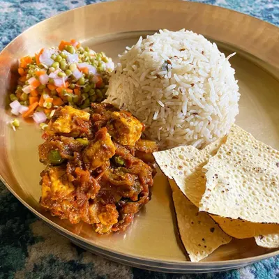 A balanced and wholesome meal on a single plate. This features my biriyani masala with paneer, served with caramelised rice, a fresh sprout salad, and crispy papad.