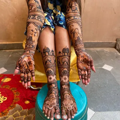 A complete bridal mehandi look, with matching designs for both hands and feet. The artwork features detailed portraits and traditional patterns, ensuring the bride looks perfect from head to toe.