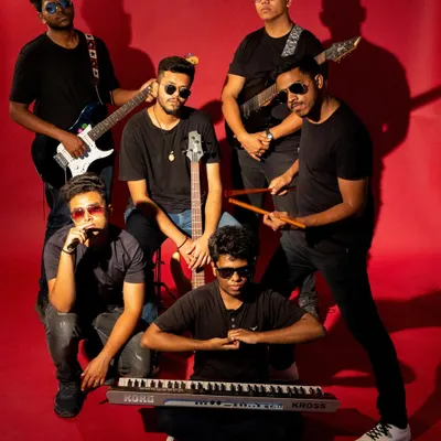 A full-group shot of a music band against a vibrant red background. This classic band promo shot establishes their collective identity and highlights their instruments, conveying energy and professionalism.