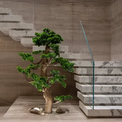 This stunning faux bonsai, set against minimalist marble and wood, exemplifies sculptural elegance. It's a perfect example of how a single plant can become a piece of living art in a modern home.