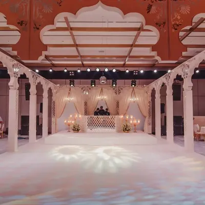 A wide view of the palatial stage we constructed, complete with a pristine white dance floor. The design was centered around tall, standing arches to enclose the space and create the feel of a royal courtyard.