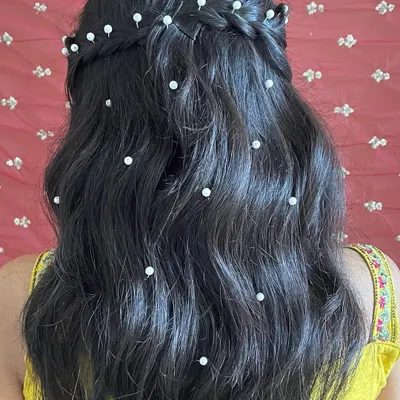 A detailed view of this beautiful half-up hairstyle with pearls scattered through the waves. This is a romantic and popular choice for bridesmaids and wedding guests.