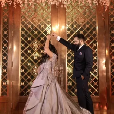 The first dance as an engaged couple. This beautiful shot captures the groom twirling his bride-to-be under a stunning floral chandelier, creating a fairytale moment.
