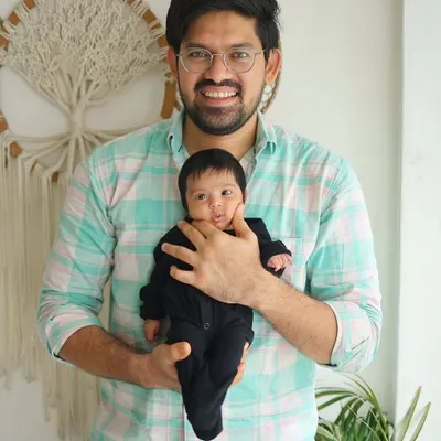 It's me, Lakhan, with one of my adorable clients. I love getting to know the babies and families I photograph.