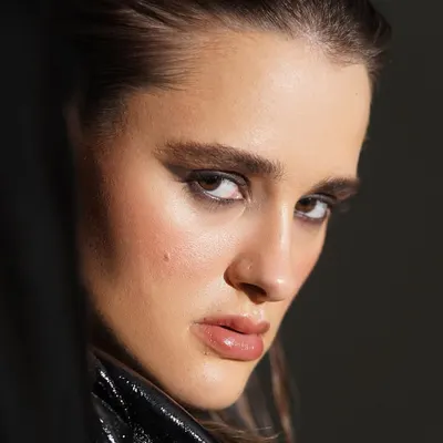 An intense and intimate close up of a graphic smokey eye. The sharp lines and deep pigment create a powerful, high fashion look, balanced by glossy, nude lips and naturally glowing skin.