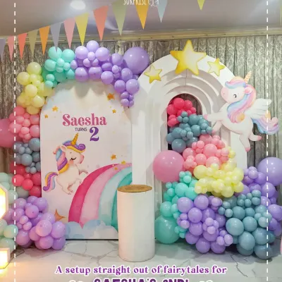 A setup straight out of fairytales for Saesha's 2nd birthday! This unicorn-themed backdrop with rainbow pastel balloon arches and a light-up number '2' was pure magic.