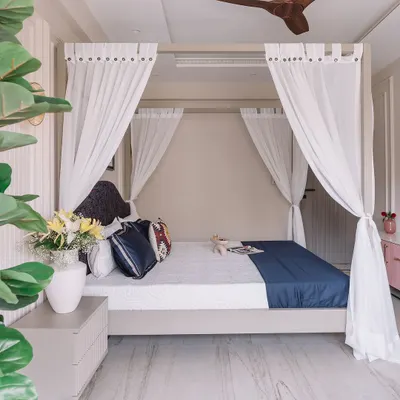 A beautiful view of the four-poster bed in our 'Modern Muse' project, draped with sheer white curtains to create a dreamy and romantic focal point.