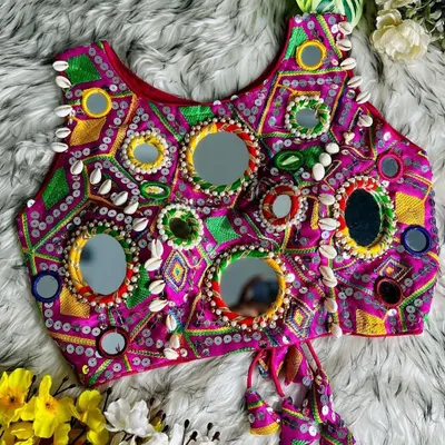 This blouse is a work of art! A magenta top covered in large and small mirrors and detailed embroidery, with cowrie shell accents. It's designed to make you shine, literally.