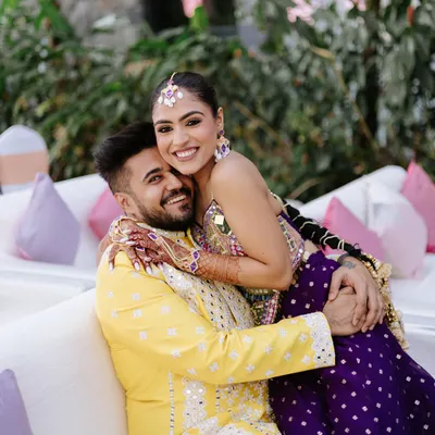 A joyful, candid hug between the couple during their mehendi ceremony. Their bright outfits and even brighter smiles capture the fun and festive spirit of the day.