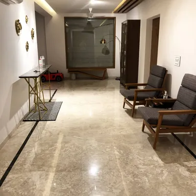 The entrance foyer of a residential project in Hyderabad. We designed the sleek console table with a geometric gold base and a pair of comfortable wooden armchairs to create a welcoming space.