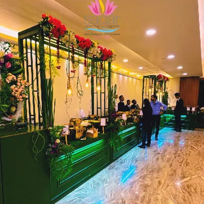 A wide view of our green and gold themed buffet setup, designed to feel both lush and luxurious. This display integrates floral decor and strategic lighting to create an impressive dining line for guests.