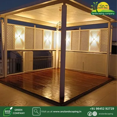 This is the same white gazebo from a different angle, showing the beautiful wooden deck flooring and warm interior lighting. This structure is perfect for creating a defined, semi-private seating area on any rooftop.