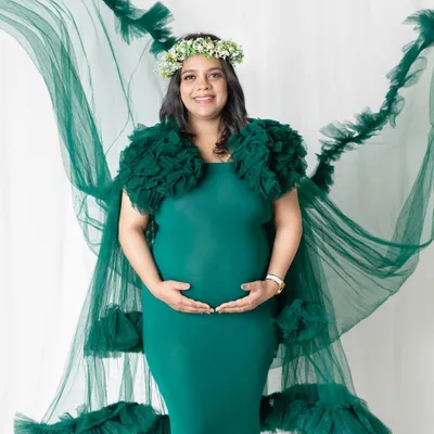 A full-length portrait showcasing our beautiful flowing green gown. The way the fabric drapes and flies creates such a dreamy effect. This is a perfect choice for moms who want a touch of drama in their maternity photos.