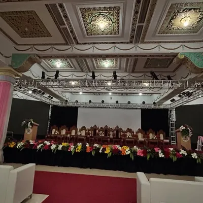 A wide-angle view of a formal event hall we prepared for a government meeting. The setup includes a complete stage with a lighting truss, a red carpet aisle, and organized seating for the audience.