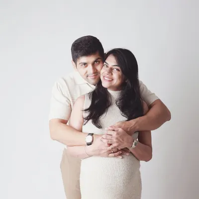 A warm embrace from behind, a classic pose that feels safe and full of love. This is a perfect shot to capture the support and partnership you share on this journey.