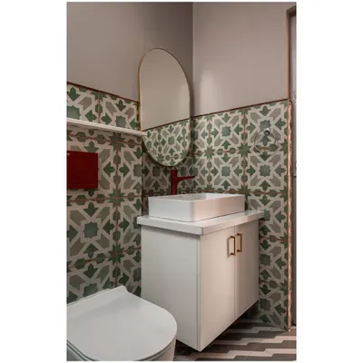 A bathroom transformation using bold geometric and floral-patterned tiles, a floating vanity, and a pop of color with a red faucet.