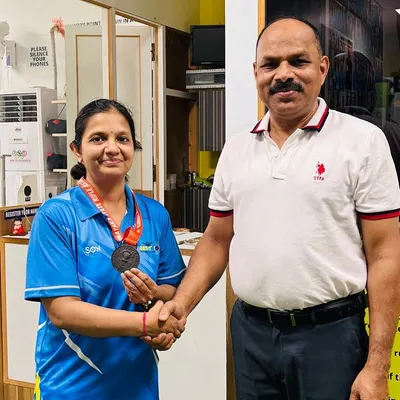 A handshake of congratulations. A proud moment with one of our medal winners at the academy after her success in the Air Rifle event.
