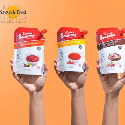 This shot uses a simple, effective concept to showcase product variety. Having hands hold up the different sauce pouches against a bright, solid background is a clean way to display the range.