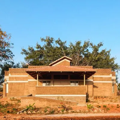 This building demonstrates the principle of emphasis, where the sloped Mangalore tile roof becomes a focal point. The structure is built with compressed stabilized earth blocks, showcasing how vernacular architecture can create visually striking and sustainable homes.