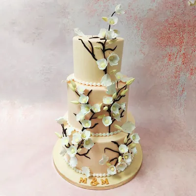 Our Three-Tier Cherry Blossom Wedding Cake is the epitome of elegance, with delicate, hand-crafted sugar blossoms cascading down the soft peach tiers.
